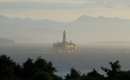 An oil rig appears in the middle of the ocean offshore Alaska's coast