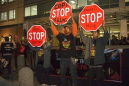 Protestors hold stop signs up at a rally