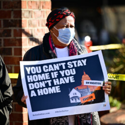 Woman holds a sign at an anti-eviction protest