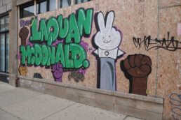 A mural to Laquan McDonald appears on the side of a building