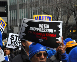 A man holds an anti voter suppression sign during a protest