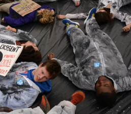 Pipeline protestors stage a die-in in oil stained suits