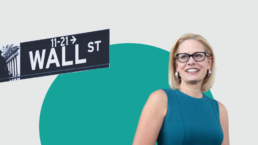 Senator Sinema stands against a green background with a Wall St sign in the corner
