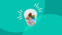 a cup of pills on green background