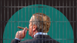 Jail cell bars cover a businessman smoking a cigar