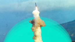An icbm ballistic missile launches from the coast into the air