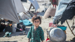 An Afghan girl stands in the middle of a refugee camp in Afghanistan