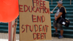 Free Education End Student Debt Sign on the Campus of the University of Hawaii Manoa next to red balloons during protest of the cost of college.