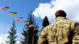 usa soldier in ukraine under american and Ukraine flags
