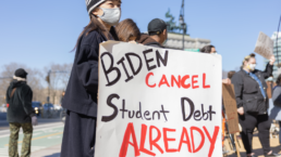 demonstrator with sign that says Biden cancel student debt now