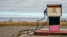 A rusty oil pump with a seascape in the background