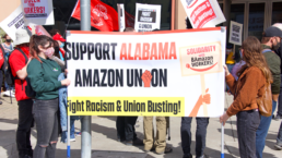 Amazon workers with sign that says support alabama amazon union fight racism and union busting in Bessemer, AL