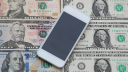 Mobile phone on dollar cash banknote, digital money and finance technology concept