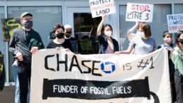protestors with banner that says Chase Bank is number 1 Funder of Fossil Fuels