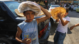 Syrian boys sells flatbread in Damascus