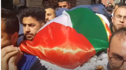 A coffin draped with the Palestinian flag is carried by protestors