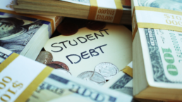 student debt sticky note under piles of cash