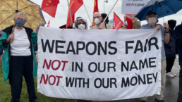 protest banner reading weapons fair NOT in our name NOT with out money