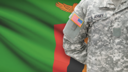 us army soldier in front of zambia flag