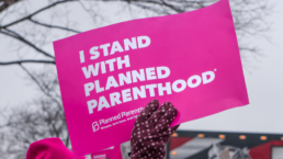 hand holding sign up that reads i stand with planned parenthood