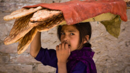 A child collects bread at a market in Kabul