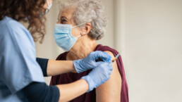 An older woman receives a covid vaccine