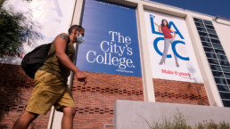 A man walks outside of a community college facade