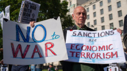 Anti-war protester with posters at the DON'T ATTACK IRAN protest in Whitehall, London, to put pressure on the UK government to publicly oppose any allied military action.