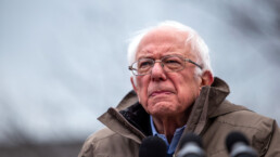 Bernie Sanders looks off into the distance at an outdoor rally