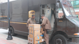 UPS workers unload packages on a street corner