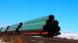 Railway flatcar loaded with large diameter pipe destined for use on the Trans Mountain Pipeline in Western Canada