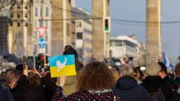 Mass rally in Berlin, Germany, at the Brandenburg Gate with people protesting against the war in the Ukraine with peace symbols and the Ukrainian flag