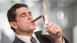 rich guy lighting cigar with burning money