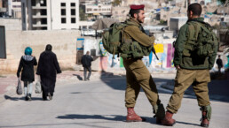 Protecting a small Israeli settler enclave, Israeli soldiers patrol among Palestinian pedestrians in Hebron, West Bank