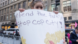 girl holding sign that says defend the forest stop cop city