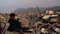 A child from Taiz City sits on the ruins of his ruined home because of the war on city-Yemen.