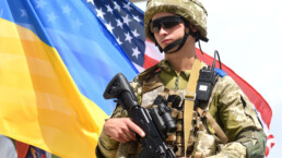 Ukrainian soldier near flags of Ukraine and US during the Three Swords 2021 multinational military exercise near Yavoriv in western Ukraine.