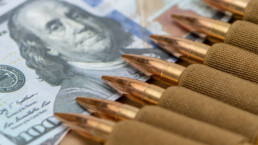 Cartridges with bullets in a bandolier, dollar bills