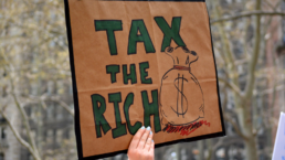 tax the rich sign at protest