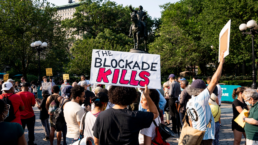 protest sign reads The Blockade Kills