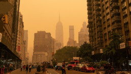 the nyc skyline is turned orange by smoke