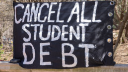 A protest banner is seen near Grand Army Plaza during a rally to cancel student loan debts.