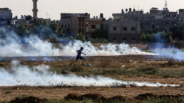 a child runs through smoke during an uprising in palestine
