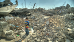 a child stands amid the ruins of a bombed building in gaza