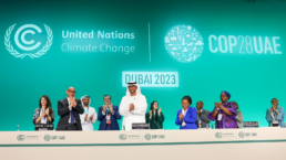 attendees stand at a cop28. meeting