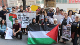 students hold flags and protest banners at a palestine protest