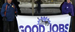 workers in minnesota hold a protest sign
