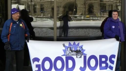 workers in minnesota hold a protest sign
