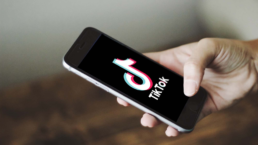 a user holds a phone with tiktok on the screen