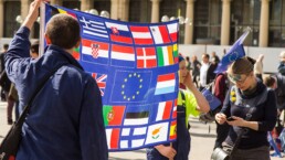 activists hold a sign showing flags of various european countries